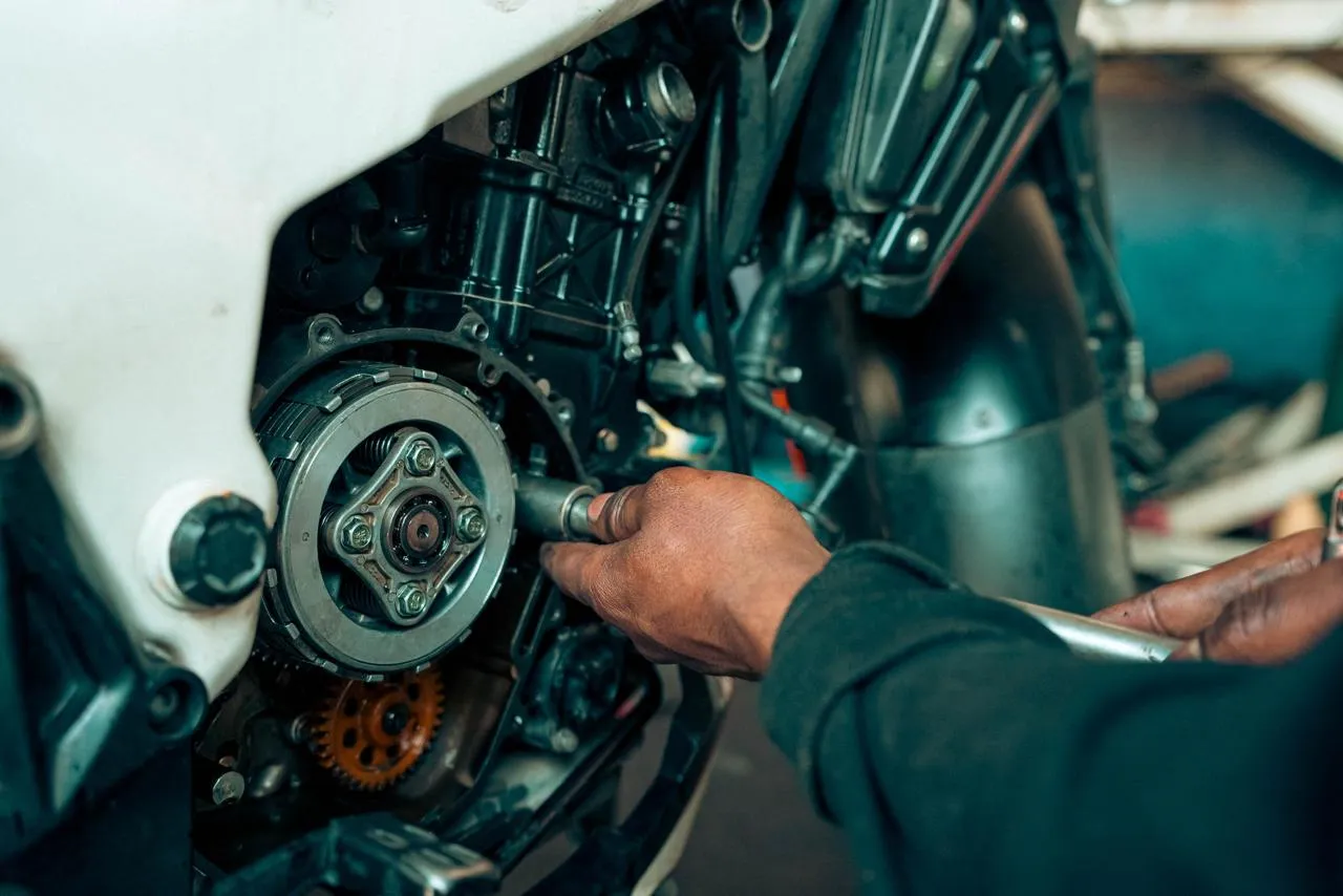 Mechanic's hands working on a motorcycle clutch